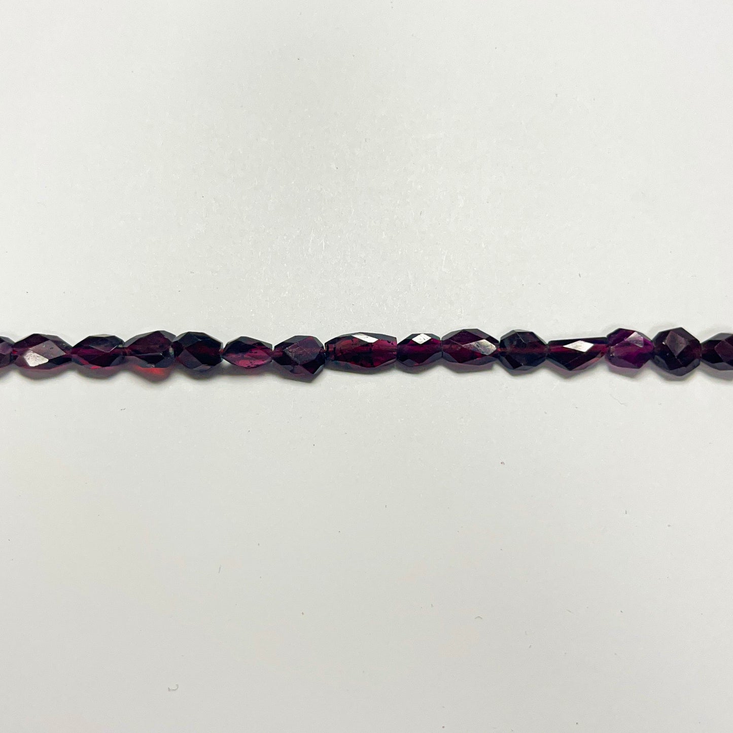 7–7.5mm x 5–5.5mm Faceted Oval Garnet 14 inch ~56 pcs/strand